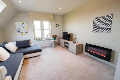 a living room with a couch and a fireplace at SHAMBALLA logies nieuw en zeer verzorgd appartement met voortuin en terras in Deinze