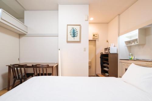 a bedroom with a white bed and a table at Wen's House-Akatsuka in Tokyo