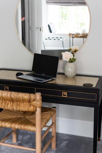 a desk with a mirror and a laptop on it at Old Abbey House in Abingdon