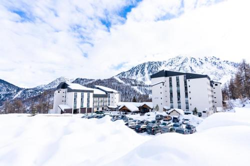 a resort in the snow with mountains in the background at Villages Clubs du Soleil - MONTGENEVRE in Montgenèvre