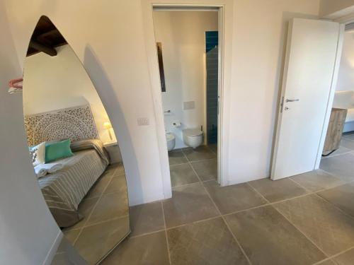 een badkamer met een spiegel in het midden van een kamer bij Rena Bianca Residence 225 in Baja Sardinia