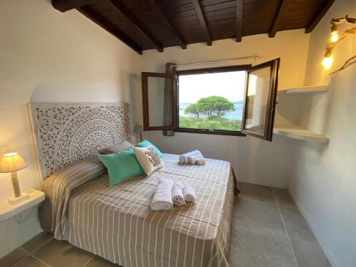 een slaapkamer met een bed met handdoeken erop bij Rena Bianca Residence 225 in Baja Sardinia