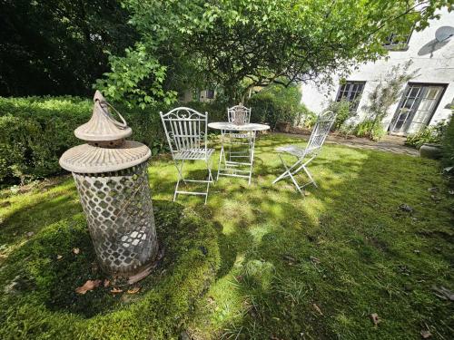 a table and chairs in a yard with a table and chairs at West Wing Lurley Manor in Washfield