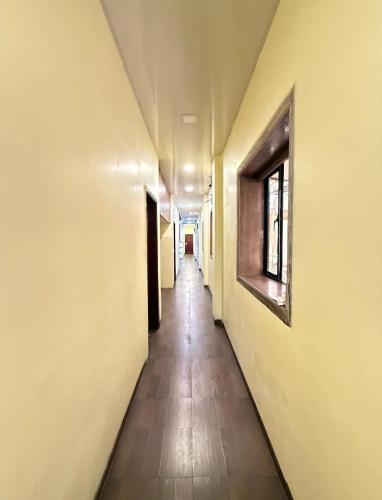an empty hallway with a long corridor with a window at P A Residency in Mumbai