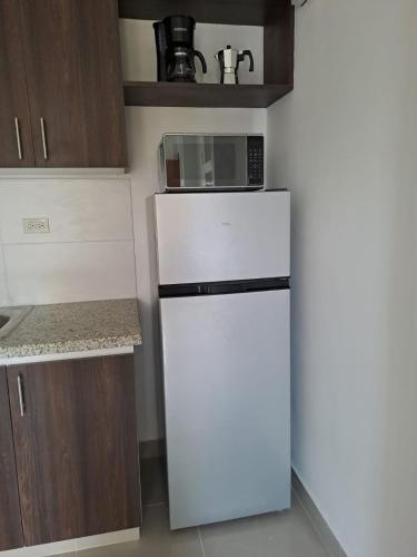 a white refrigerator with a microwave on top of it at New apartment near the airport AILA 