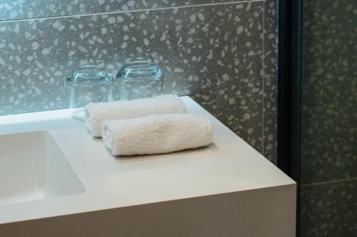 two rolled towels sitting on a counter in a bathroom at Artifact Apart Hotel in Tbilisi City