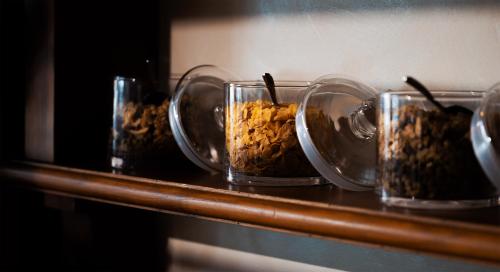a row of glass containers filled with food on a counter at Porto Lotti Suite Hotel in La Spezia
