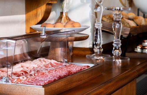 a counter top with a tray of meat and eggs at Porto Lotti Suite Hotel in La Spezia