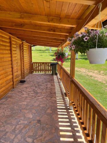 a wooden covered porch with a potted plant at Vikendica Neprivaj in Vareš