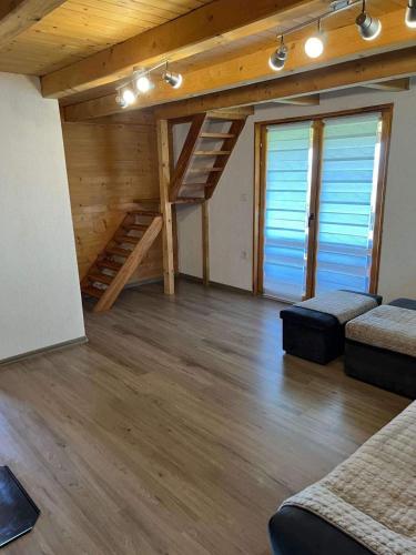 a large room with wooden floors and wooden stairs at Vikendica Neprivaj in Vareš