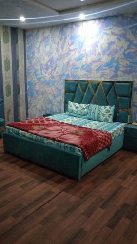 Bett in einem Zimmer mit einer farbenfrohen Wand in der Unterkunft safari hotel shimlapahari in Lahore