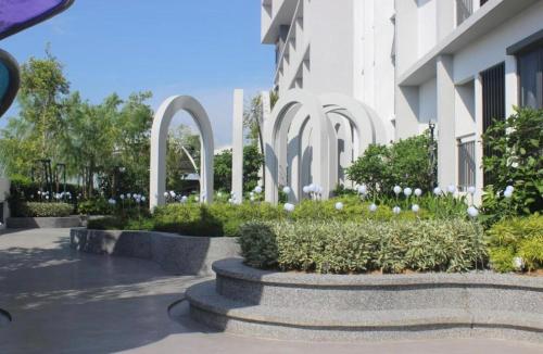 a courtyard with white flowers and a building at 22 Macalisterz 2025 Georgetown Premium 顶楼无边泳池 in George Town