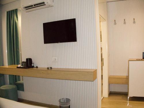 a hotel room with a bar with a television on the wall at Ilio Boutique Hotel in Ksamil