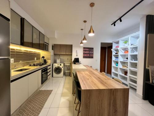 a kitchen with a wooden counter top in a room at Bee Guest - Apartamentos de Temporada Luxxor Flat in Cuiabá