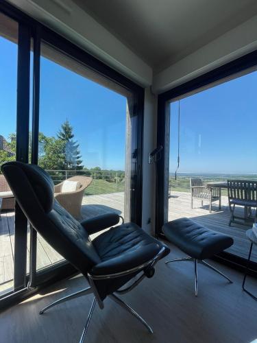 a room with two chairs and a large window at S'évader vers l'horizon 6pers, calme, wifi in Chalvignac