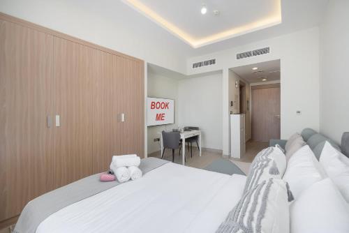 a bedroom with a large white bed and a desk at StayShort - Meydan Apartment sleeps 4 with a Private Balcony in Dubai