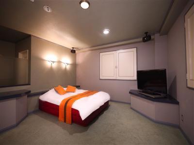a bedroom with a bed and a flat screen tv at ホテルピースプラス in Kamisu