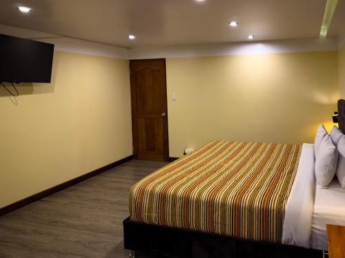 a hotel room with a bed and a flat screen tv at Santuario Machupicchu in Machu Picchu