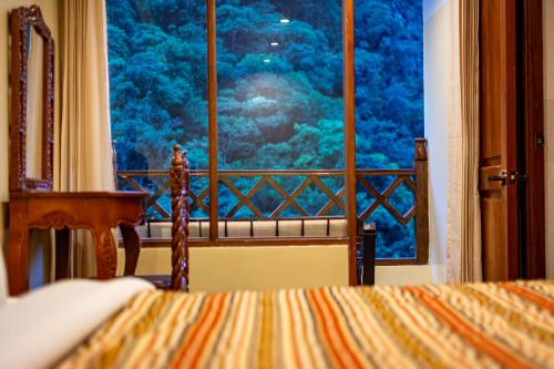 a bedroom with a window with a view of trees at Santuario Machupicchu in Machu Picchu