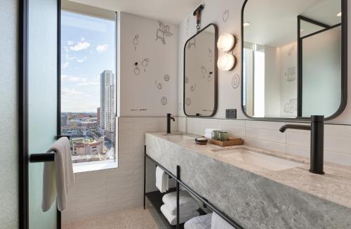 a bathroom with a sink and two mirrors at Caption By Hyatt Central Sydney in Sydney