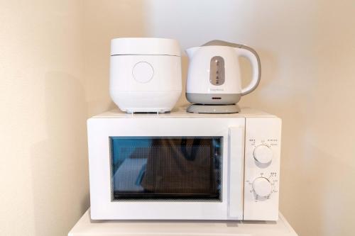 a microwave with a blender and a coffee pot on top at 801Room,Sky Tower 12 minutes walk Sensoji Temple 15 minutes walk New Apartment 50 m2 direct access to Haneda Airport in Tokyo