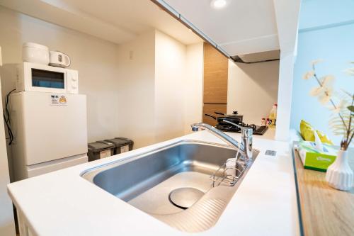 a kitchen with a sink and a refrigerator at 801Room,Sky Tower 12 minutes walk Sensoji Temple 15 minutes walk New Apartment 50 m2 direct access to Haneda Airport in Tokyo