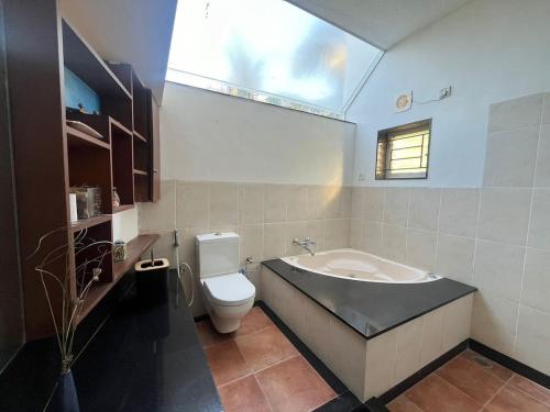 a bathroom with a tub and a toilet and a sink at sandyview-Private Villa On ECR, chennai Beach in Chennai