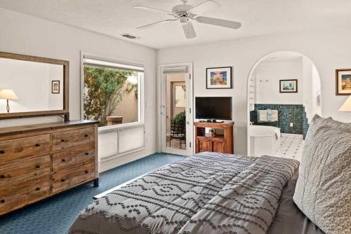 a bedroom with a bed and a dresser and a television at Spacious Sedona Splendor with Community Spa & Pool in Sedona