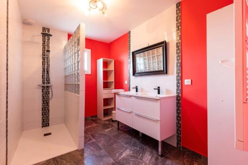a bathroom with red walls and a white sink at Maison Cœur Des Vignes in Les Salles-de-Castillon