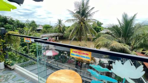 a balcony with blue chairs and palm trees at HOMESTAY Hoàng GIa in Ấp Ông Tú