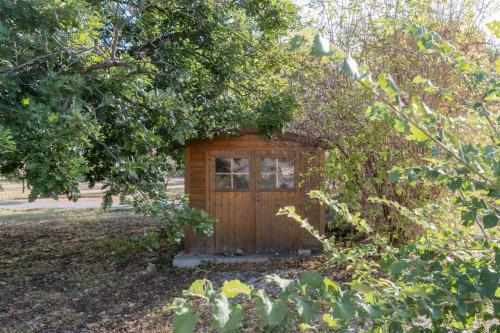 a small wooden shed with a window in a yard at Gîte Chêne ou Murier in Les Vans