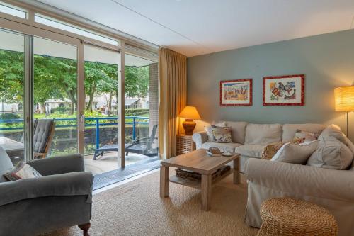 a living room with a couch and a table at Hello Zeeland - Appartement Park loverendale 25 in Domburg