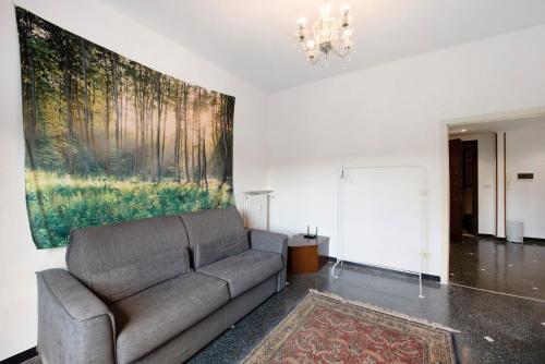 a living room with a couch and a painting on the wall at Outlet2000 in Serravalle Scrivia