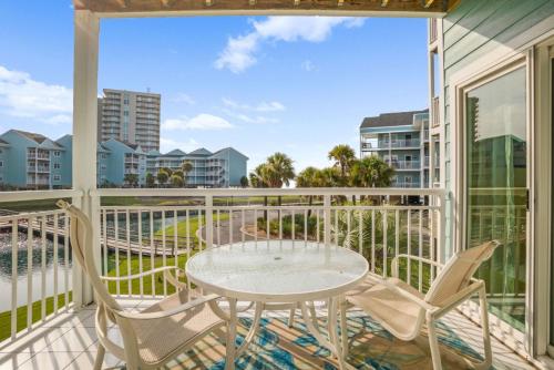 un patio con tavolo e sedie su un balcone di Baywatch F-3 a Villa Sabine