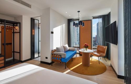 a hotel room with a bed and a chair and a table at Caption By Hyatt Central Sydney in Sydney
