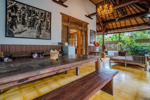 una sala de estar con una gran mesa de madera. en Imagine Bali, en Ubud
