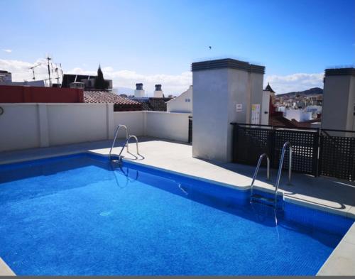 a swimming pool on the roof of a building at ROOMS Malaga Centro Jinetes in Málaga