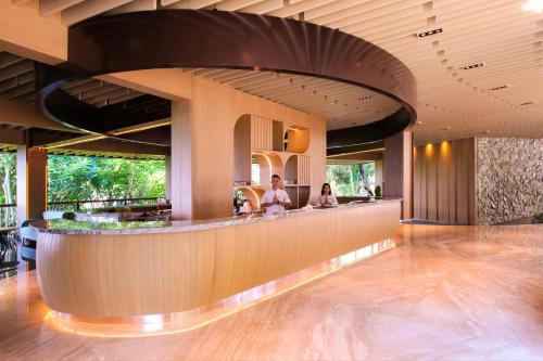 un hall d'hôtel avec des gens assis à un bar dans l'établissement Hotel Santika Premiere Hills Resort Cibadak Sukabumi, à Cibadak