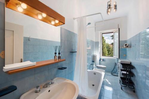 a blue and white bathroom with a sink and a shower at Outlet2000 in Serravalle Scrivia