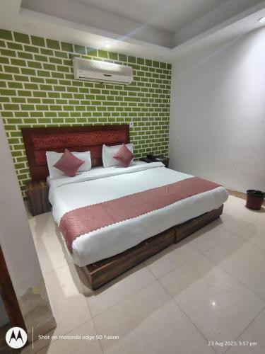 a bedroom with a large bed with a brick wall at Hotel Banke Bihari Stays in Vrindāvan