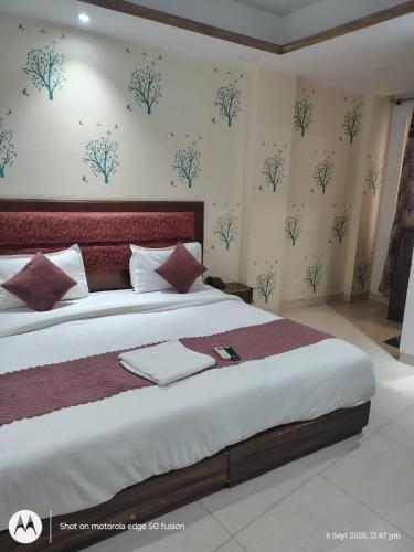 a bedroom with a large bed with a red headboard at Hotel Banke Bihari Stays in Vrindāvan