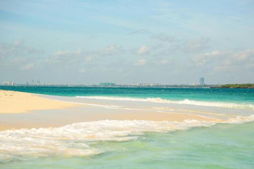 a beach with the ocean and a city in the background at Holiday Inn Dar Es Salaam by IHG in Dar es Salaam