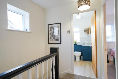 a hallway with a staircase and a bathroom with a toilet at 3-Bed House, Sleeps 5,Bedford in Marston Moretaine