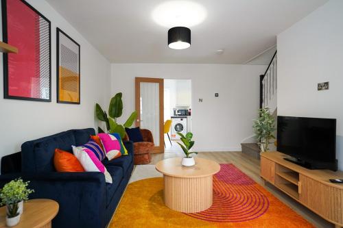 a living room with a blue couch and a tv at 3-Bed House, Sleeps 5,Bedford in Marston Moretaine