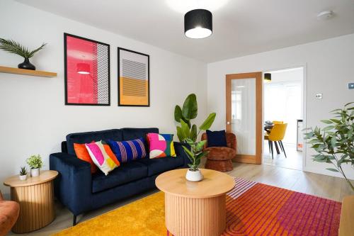 a living room with a blue couch and a table at 3-Bed House, Sleeps 5,Bedford in Marston Moretaine
