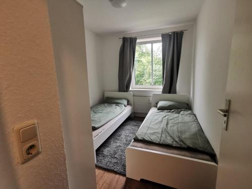 two beds in a small room with a window at Schwerin APARTmentS für Monteure in Schwerin