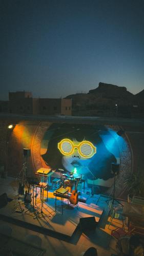 a pool with tables and chairs at night at taman'art space in Aït Ben Haddou