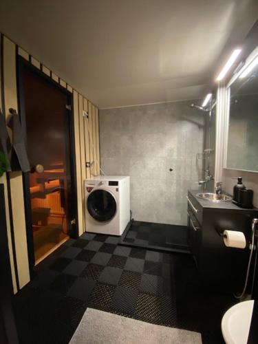 a bathroom with a sink and a washing machine at Cozy apartment from Raahe! in Raahe