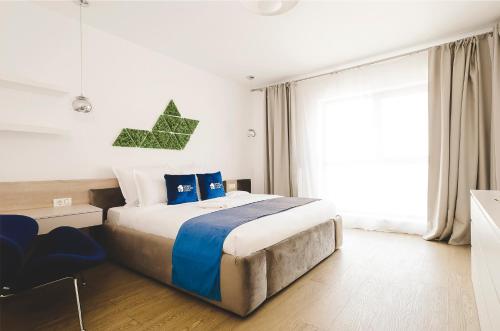 een slaapkamer met een groot bed en een raam bij Smart Stay Plaza in Boekarest