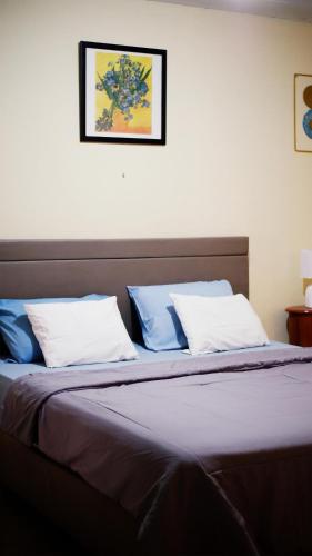 a bedroom with a bed with blue and white pillows at Pondok Kalimaya in Serang